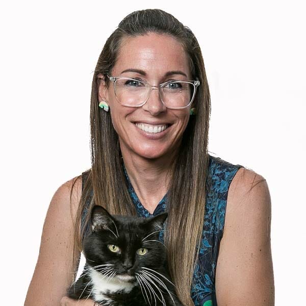 Emergency Medicine Veterinarian and Medical Director of MedVet Akron, Dr. Chiara Costanzo, smiling and holding her black and white pet cat