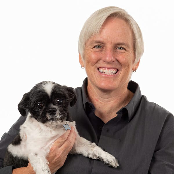 Critical Care Specialist and Medical Director of MedVet Mountain View, Dr. Monica Clare, hugging her black and white pet dog.