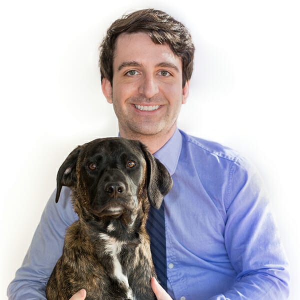 Emergency Medicine Veterinarian and Medical Director of MedVet Dayton, Dr. Kevin Przybylski, hugging his brown pet dog.