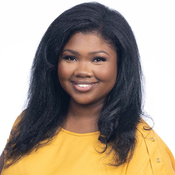 Hospital Director, Tavia Moore, smiling while wearing a bright yellow shirt