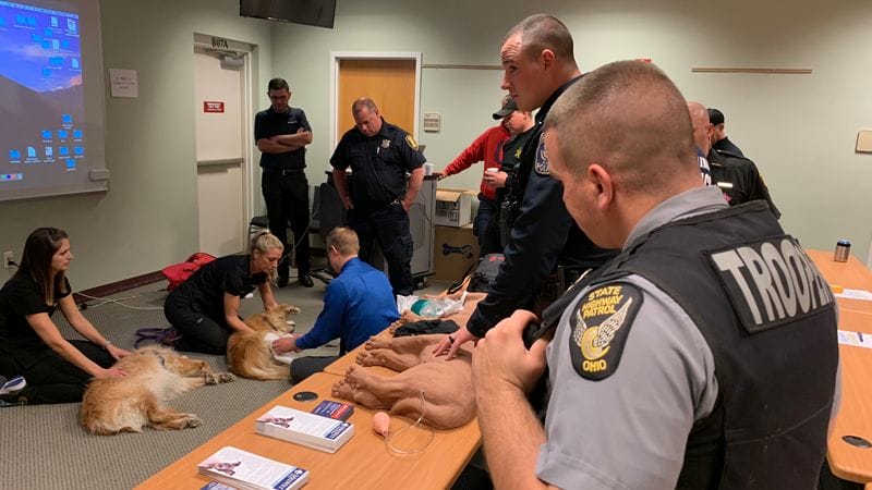State police officers in classroom learning how to give CPR to dogs in an emergency