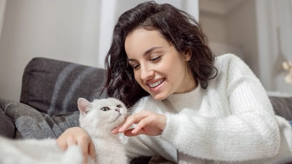 Pet-owner-looking-happy-while-spending-time-with-her-cat